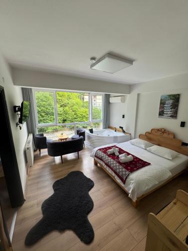 a bedroom with a large bed and a large window at Pine Suit in Çamlıhemşin