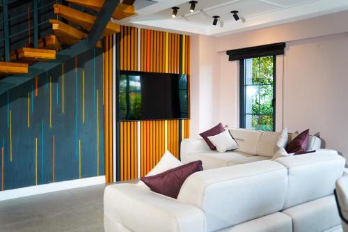a living room with two white couches and a tv at Juglans Suites in Fethiye