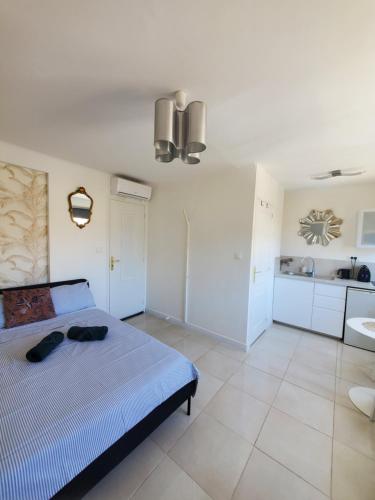 a bedroom with a blue bed and a kitchen at Cannes Centre Studio Lumineux et Chic, à 9 Min à Pied du Palais des Festivals et des Plages, Clim in Cannes