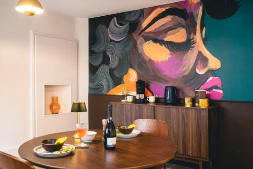 a dining room table with a painting on the wall at Le Cocopop in Dinant
