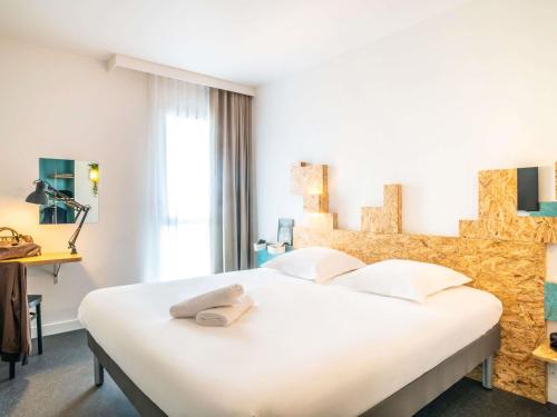 a bedroom with a large white bed with white pillows at greet Hotel Rennes Pace in Pacé