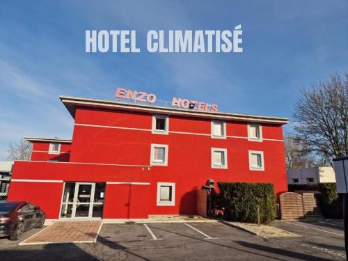 a red building with the words hotel luminate on it at Enzo Hotels Reims Tinqueux in Reims