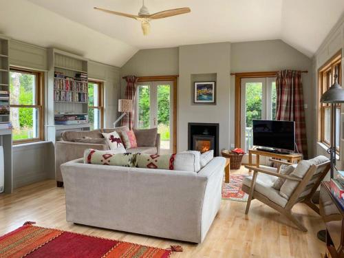 a living room with two couches and a tv at Ardtur Croft in Appin