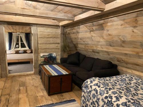 a room with a couch and a bed and a mirror at Tolvmansgården in Enköping