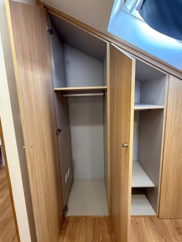 an empty closet with wooden doors in a room at Porta 4 City Flat in Vila Real