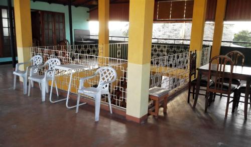 un grupo de sillas y mesas blancas en una habitación en Hotel 100, en Dehiwala