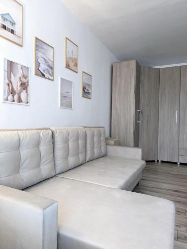 a living room with a white couch and some pictures at Ariana Urban Loft in Târgu-Mureş