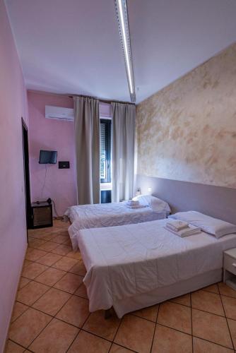 a hotel room with two beds and a window at Locanda San Martino in Collecchio