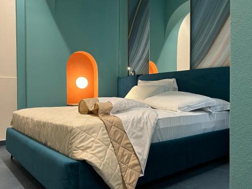 a bedroom with two beds and a light on the wall at La PEPITE in Viareggio