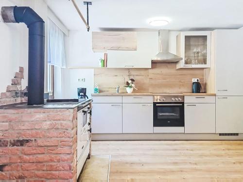 a kitchen with white cabinets and a brick wall at Apartment Loidl by Interhome in Ebensee