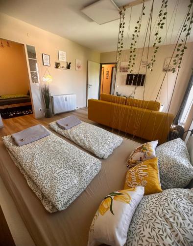 a room with three beds and a couch in it at Smile Home in Klagenfurt