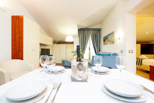 a dining table with white plates and wine glasses at Residence Dei Due Porti in Sanremo