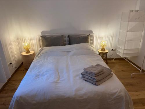 a bedroom with a white bed with towels on it at room4you Lambach Apartment, Studiozimmer & Zimmer in Lambach