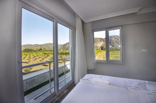 a bedroom with a bed and a large window at Villas Dogakent in Ortaca