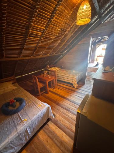 a room with a bed and a table and a window at Guest House Antsakoa in Nosy Komba