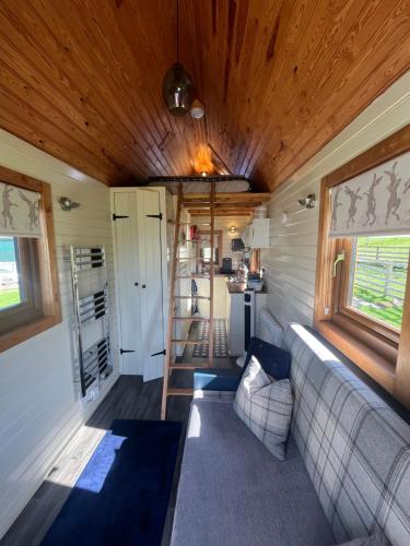 a living room with a couch in a tiny house at The Niblet Bonnie View Glamping Cabins, Helmsley in Carlton