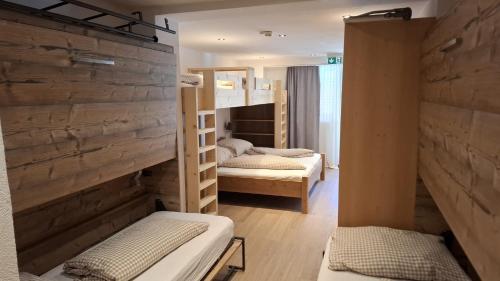 two bunk beds in a room with wooden walls at Waldhaus Talblick in Biberwier
