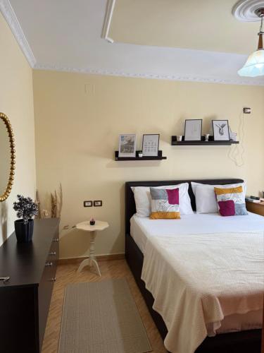 a bedroom with a bed with white sheets and pillows at Guest House Dimos Kristi in Përmet