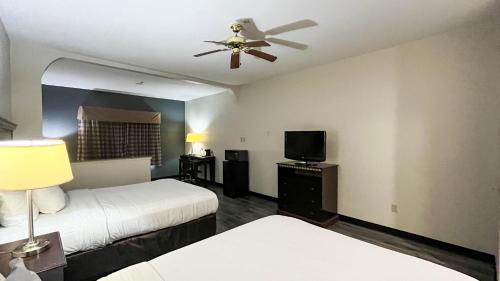 a hotel room with two beds and a ceiling fan at Studio 6 Suites Houston, TX - Spring in Houston