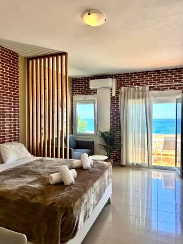 a bedroom with a bed and a view of the ocean at Nautica Hotel Apartments in Stavromenos