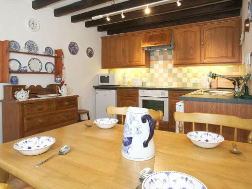 a kitchen with a wooden table with a vase on it at Cropple Howe in Threlkeld