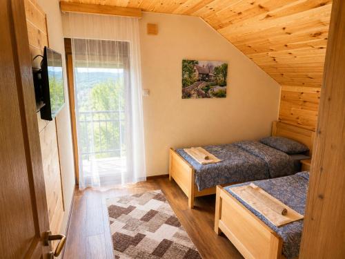 a bedroom with two beds and a window at Gacka Luxury Mountain Villa in Feratovo Polje