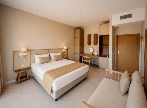 a bedroom with a large bed and a couch at VILLA BRANDA - Tavira Nature Hotel in Tavira