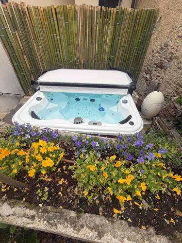 a hot tub in a garden with flowers at LevOasi 9 - Lake and mountains escape in Levo