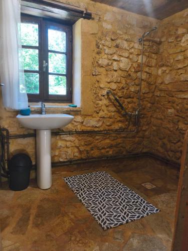 a stone bathroom with a sink and a shower at Chambre de la Tour 2 in Milhac