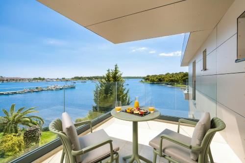 a balcony with a table and chairs and a view of the water at Visula Hotel & Spa - New Opening 2026 in Medulin