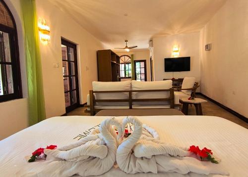 ein Schlafzimmer mit einem Bett mit zwei Schwänen aus Handtüchern in der Unterkunft Castello Beach Hotel in Grand'Anse Praslin