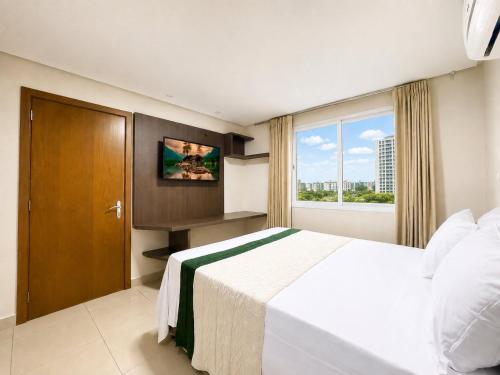 a bedroom with a large white bed and a window at Luxurious 2-Bedroom Duplex with Gourmet Balcony in Goiânia