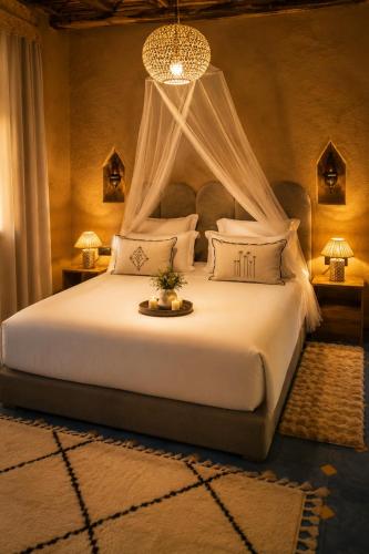 a bedroom with a large bed with a canopy at Kaha Lak in Douar Aguergour