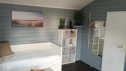 a bedroom with a white bed and blue walls at Glücks-Gezeiten in Wurster Nordseeküste