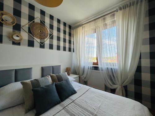 a bedroom with a bed and a window at Apartament 14 in Zwierzyniec