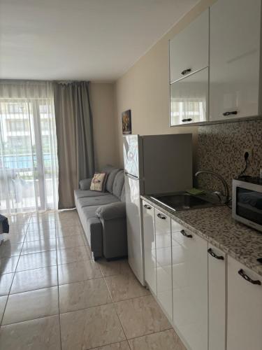 a kitchen and living room with a couch and a microwave at Sea Dreams Studio in Sveti Vlas