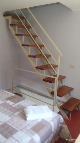 a wooden staircase in a room with a bed at Casa vacanze Torre in Cefalù