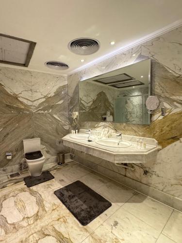 a bathroom with a sink and a toilet and a mirror at Fleet Club Mahrousa in Alexandria