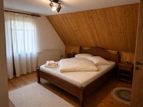 a bedroom with a bed with a wooden ceiling at Casa Rosso in Valea Măceşului