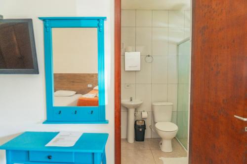 a bathroom with a blue mirror and a toilet at Pousada Acqua Bella PISCINA CLIMATIZADA in Bertioga