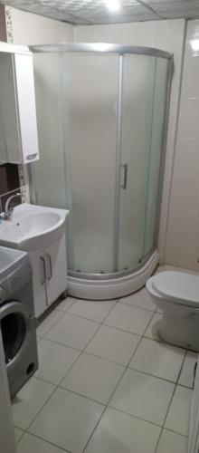 a bathroom with a shower and a toilet and a sink at Ayışık Otel in Hamidiye