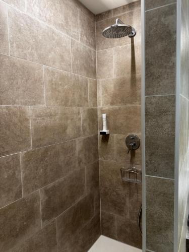 a bathroom with a shower with a glass door at GardaBreak Rooms&Breakfast Holiday Apartments in Riva del Garda