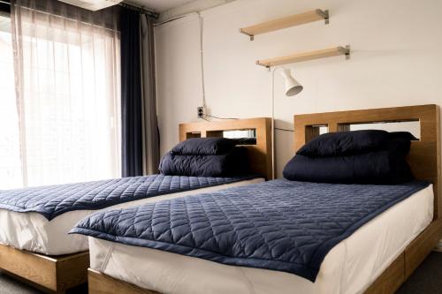 a bedroom with two beds and a window at That House Hongdae in Seoul