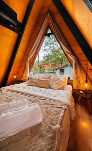 a large bed in a room with a large window at Cabana da Mata - Teresópolis in Teresópolis
