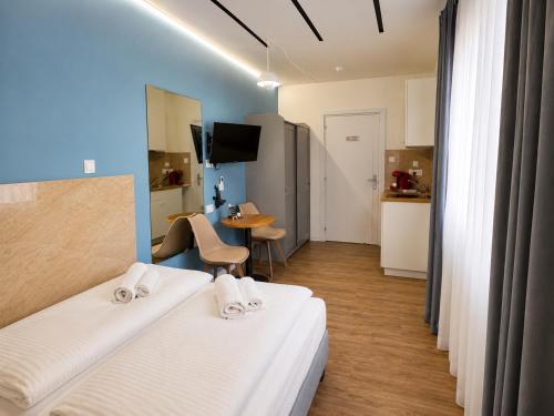 a room with two beds and a table and a kitchen at Modern Studio 7 private Kitchenette and Bathroom in Limassol