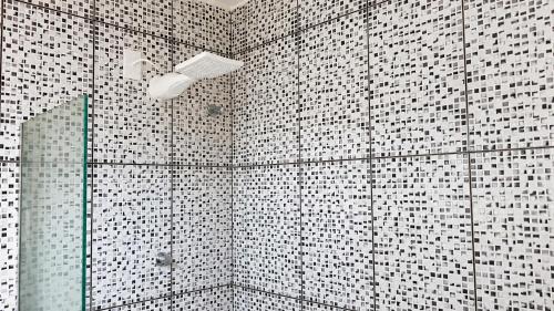 a bathroom with black and white tiled walls and a shower at BayShore Lofts in Cabo Frio