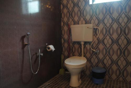 a bathroom with a toilet and a shower at Joe And Marietta's Guesthouse in Calangute