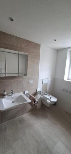 a bathroom with a sink and a tub and a toilet at Ferienwohnung zum Albuch in Nördlingen