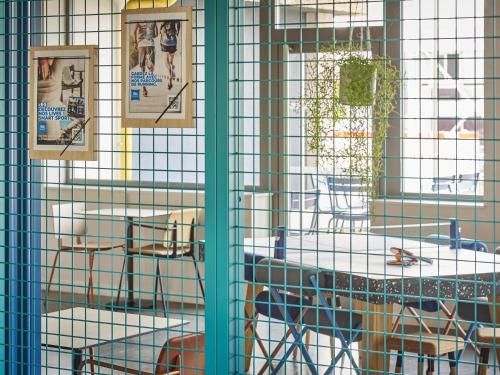 a cage with pictures on it with a table at ibis budget Nancy Laxou in Nancy