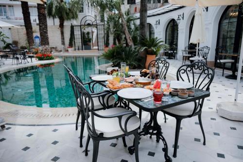 a table with food on it next to a pool at Elegance East Hotel in Antalya